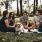 a group of people sitting on the grass with a dog
